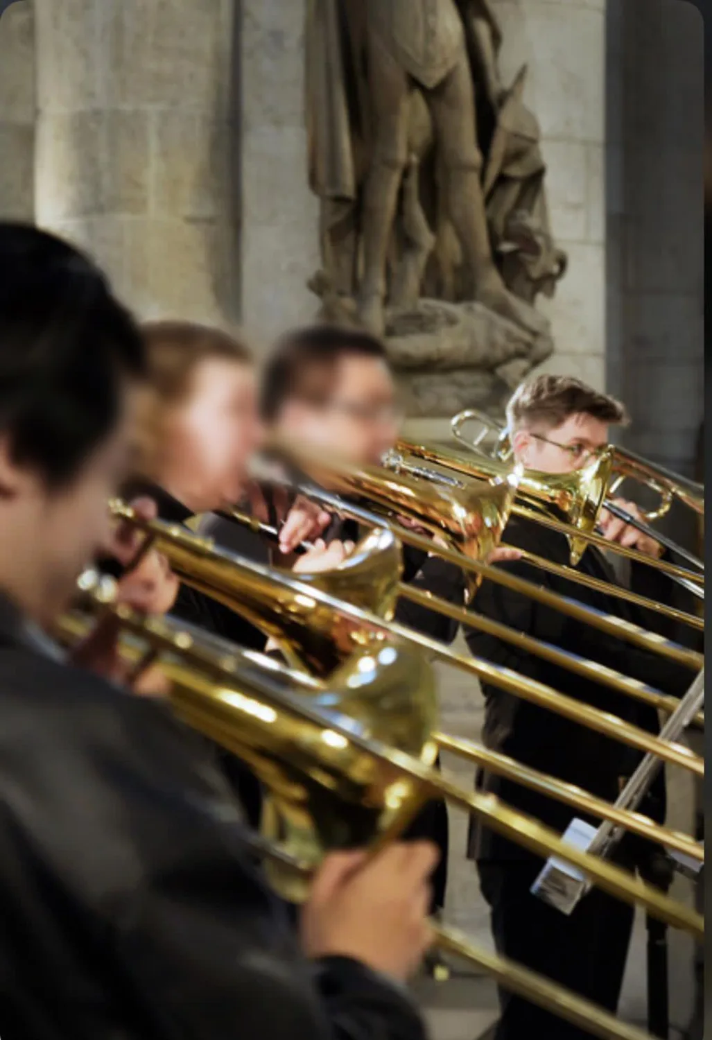 Musikensemble spielt Trompeten in einer Kirche, Maximilian Schollemann mit Brille im Fokus auf der rechten Seite