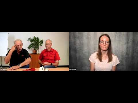 Videostandbild mit zwei Männern am Tisch links und einer Frau am Bildschirm rechts