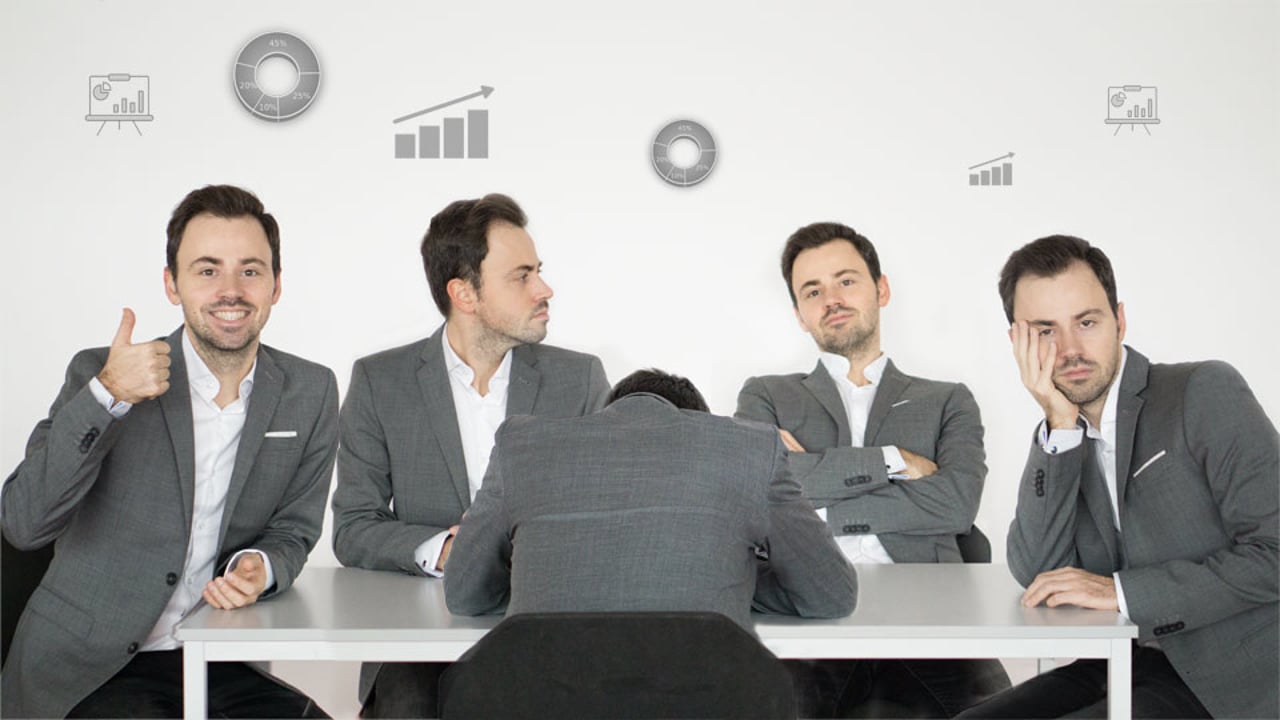 Vier Geschäftsmänner am Konferenztisch mit Business-Symbolen, Meeting-Situation