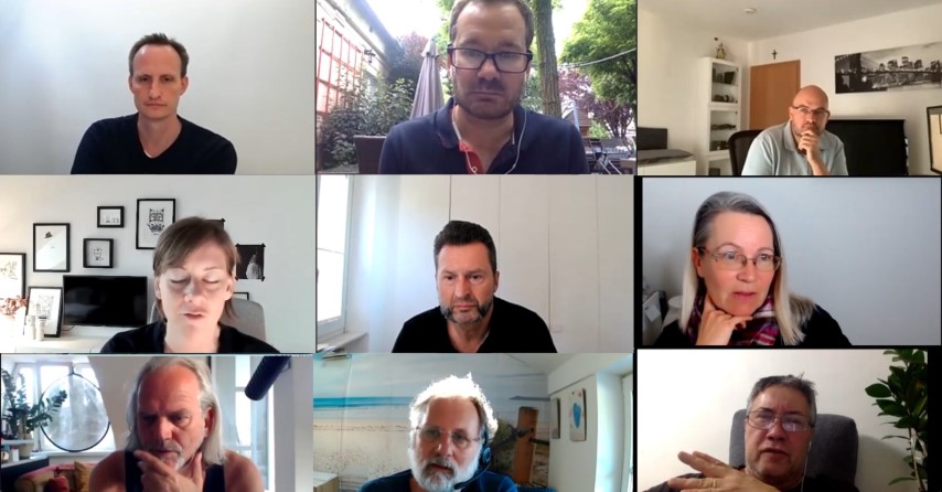 Neun Personen in einem Zoom-Videoanruf-Grid, verschiedene Wohnzimmer und Büroumgebungen