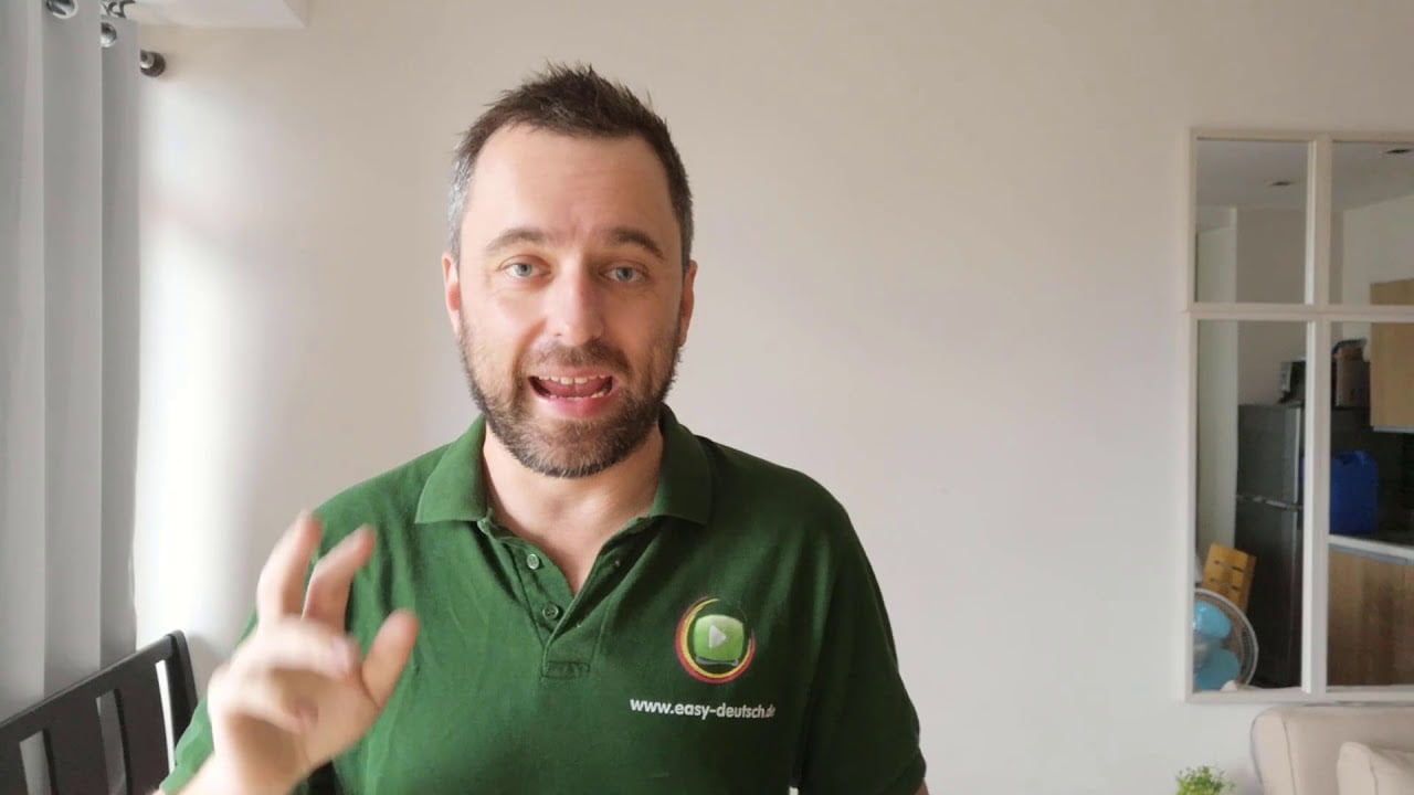 Jan Richter spricht in die Kamera mit Gesten, grünes EasyDeutsch-Poloshirt