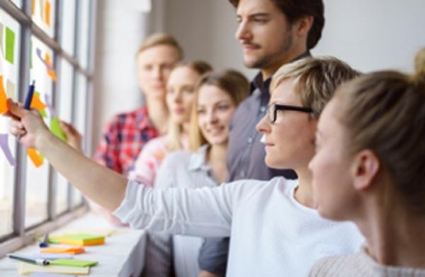 Gruppe von Menschen bei Brainstorming Workshop mit Notizblättern