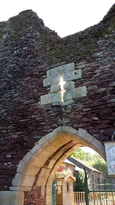 Steinruine mit Kreuz und Torbogen zu Ruine mit Garten