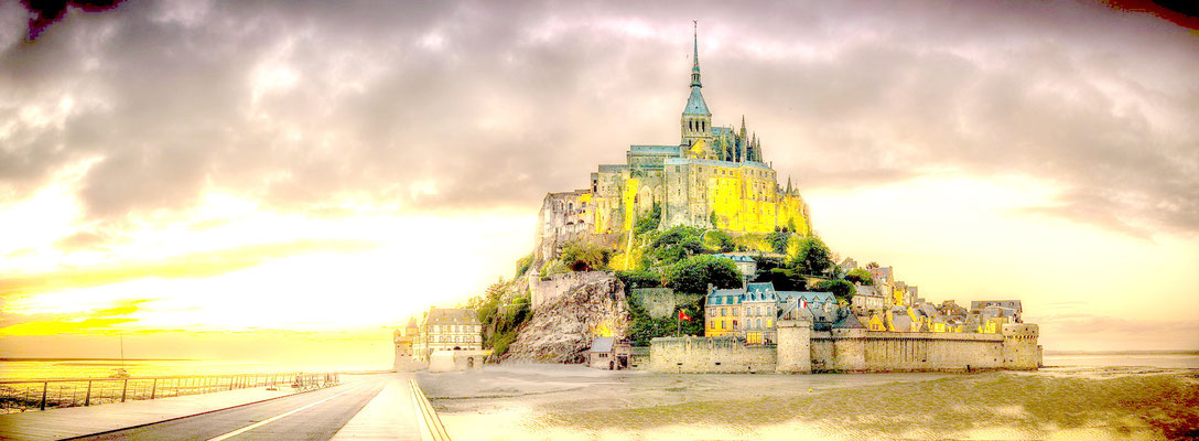 Mont Saint-Michel Insel mit leuchtender Kirche bei Sonnenuntergang