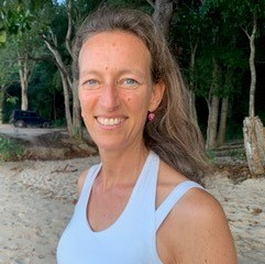 Porträt Dr. Cornelia Fach, Frau am Strand in weißem Top
