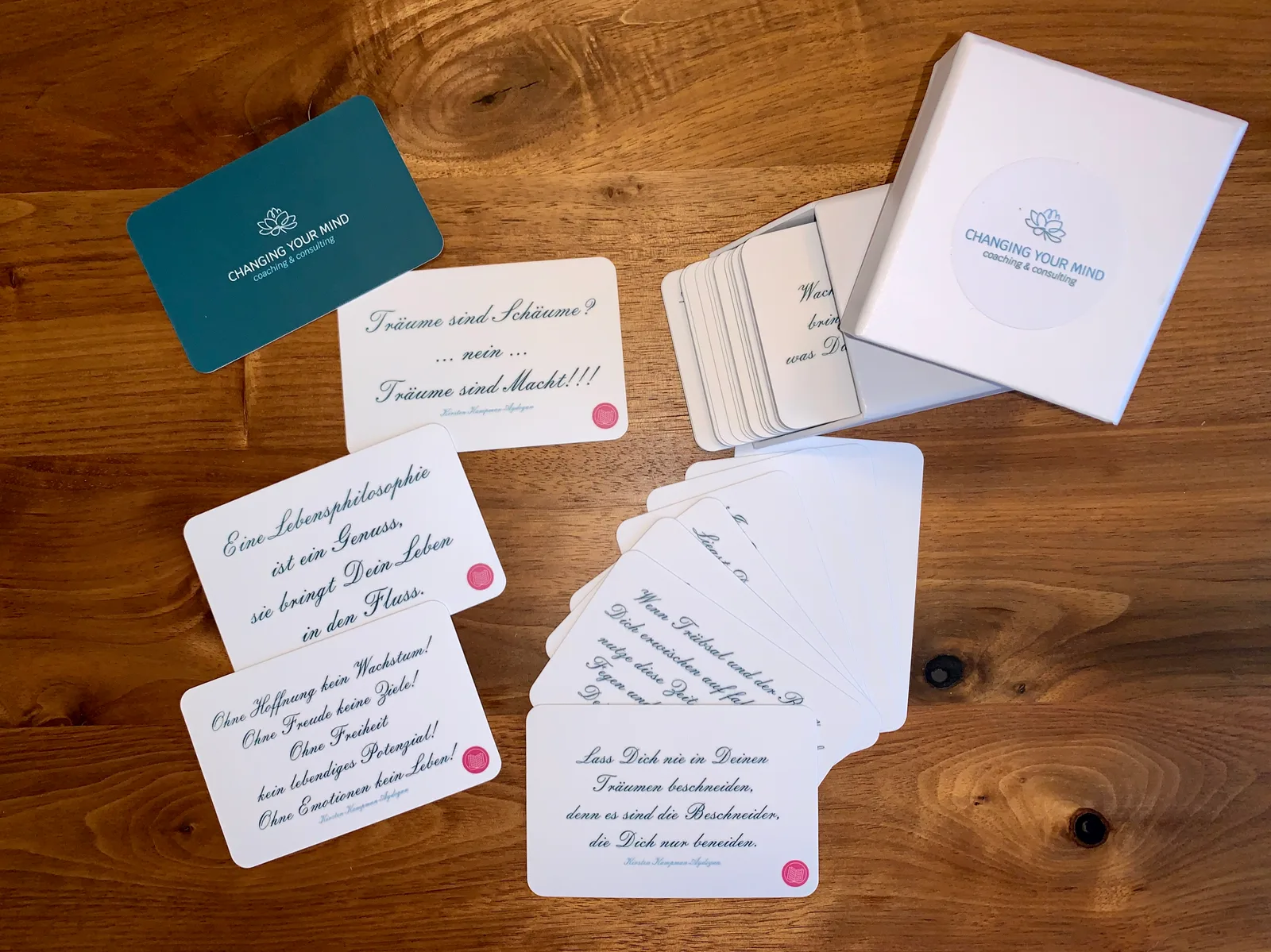 Coaching-Materialien auf Holztisch: Karten mit Zitaten, Workbook von Changing Your Mind, Visitenkarte und Box