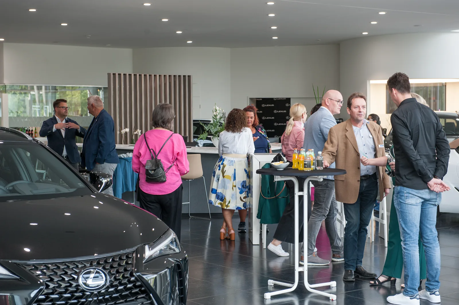 Event in modernem Autohaus mit Besuchern beim Networking und Austausch, professionelle Atmosphäre