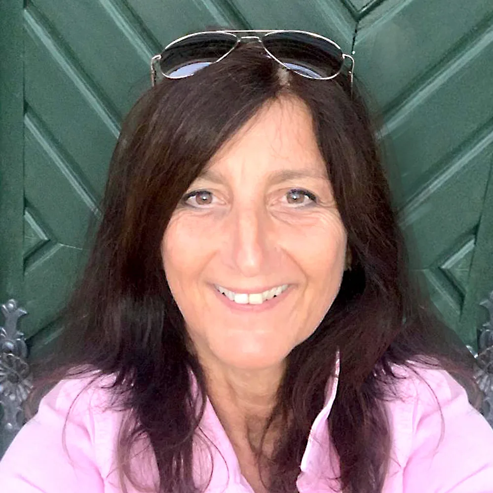 Porträt einer Frau mit dunklen Haaren und Sonnenbrille im Rosa-Outfit, Kundenstimme