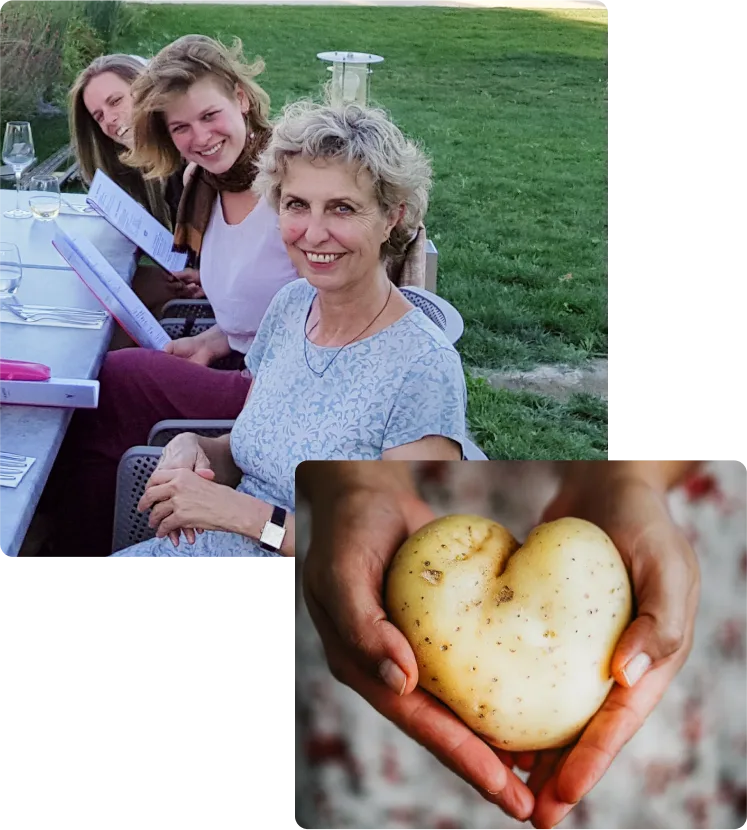 Drei Frauen bei Outdoor-Picknick auf grüner Wiese, eine hält herzförmige Kartoffel