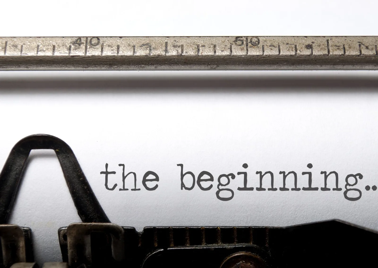 Schreibmaschine mit Text 'the beginning..' auf weißem Papier