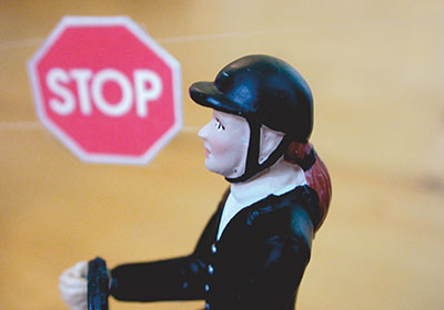 Reiter mit STOP-Schild in leuchtend pinker Farbe