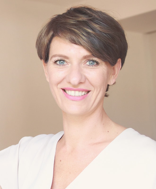 Porträt Nadine Bokarev, dunkelhaariges Frau mit magenta Lippenstift, weißes Oberteil, freundlicher Blick