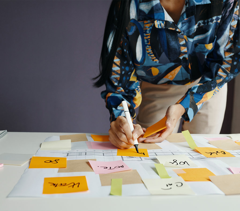 Hintergrund-Bild: Frau gestaltet Präsentation mit Sticky Notes und Mindmap-Elementen
