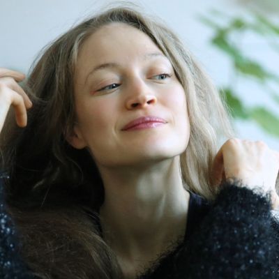 Porträt einer Frau mit langen Haaren und grünem Hintergrund