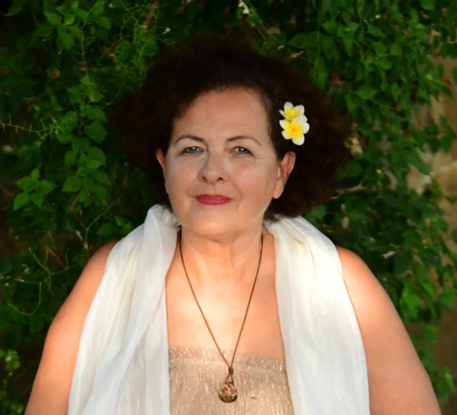 Sacred Woman Rising – Kurspaket heilige Weiblichkeit 22 Porträt von Insha Berger vor grüner Efeu-Wand mit weißem Tuch und gelbem Blumenschmuck im Haar