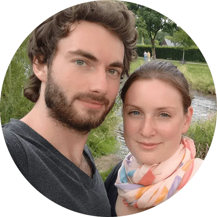 Kundenstimme Paar sitzt am Fluss und lächelt in Kamera