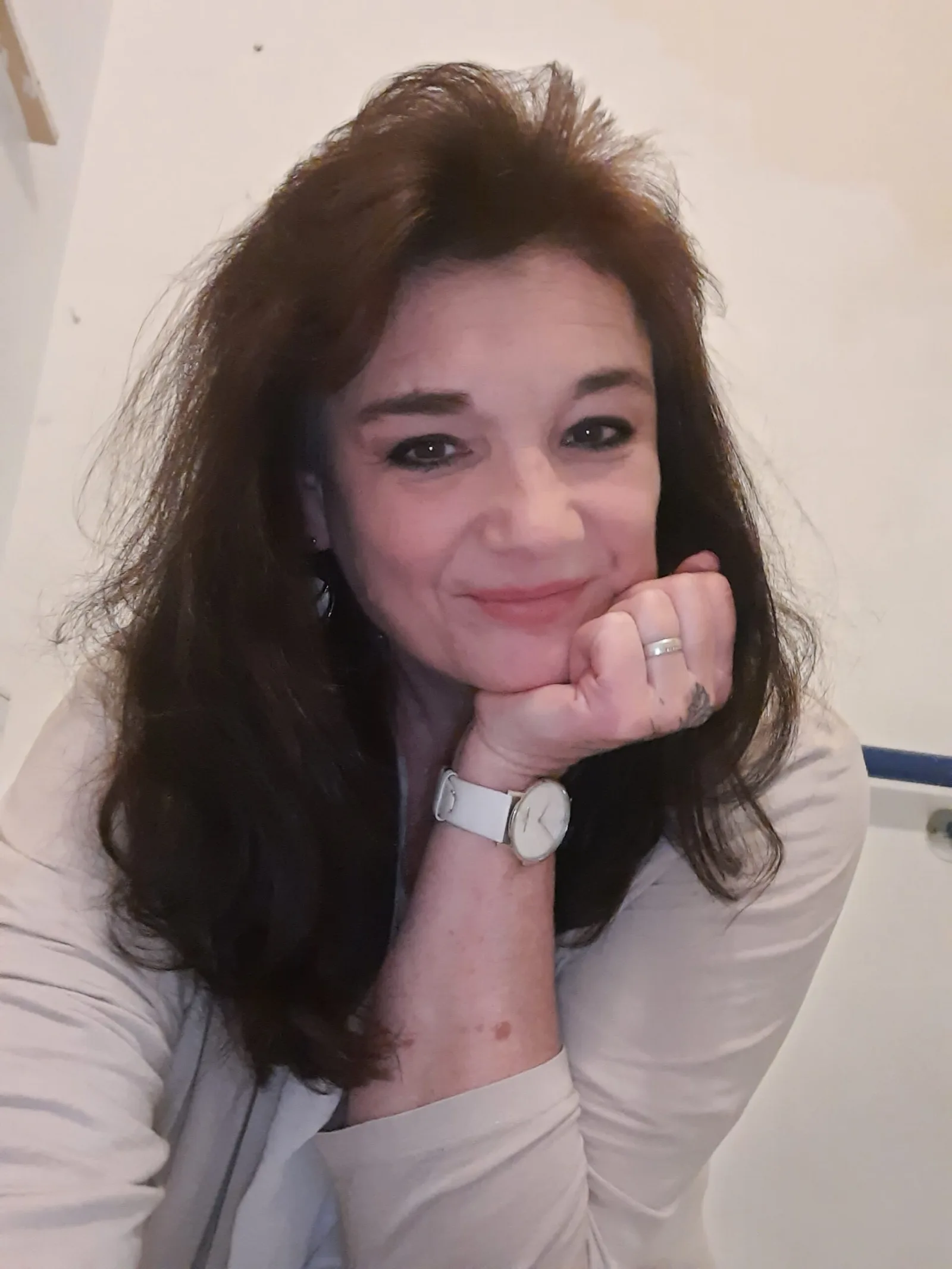 Porträt von Eva Maria Herzog, dunkelhaarige Frau mit weißer Uhr am Handgelenk