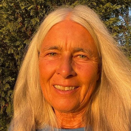 Monika Spindler mit langen blonden Haaren in Abendlicht, Baumkrone im Hintergrund
