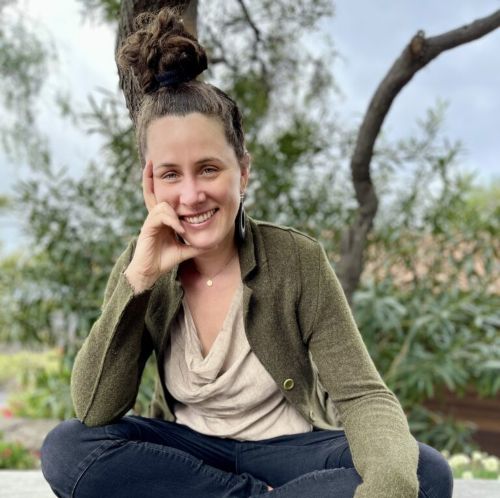 Porträt Stefanie Fischer, Frau mit dunklem Haar im Dutt, grüner Cardigan, grauer Top, Outdoor