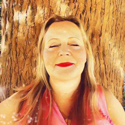 Ulrike vor Holzhintergrund mit rotem Lippenstift, Haare mit Highlights, lächelnd