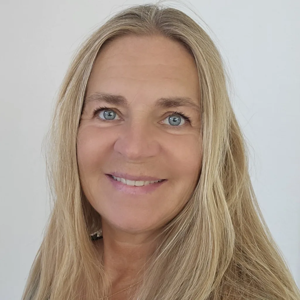 Porträt Sylvia Vera mit hellbraunem Haar vor neutralem Hintergrund