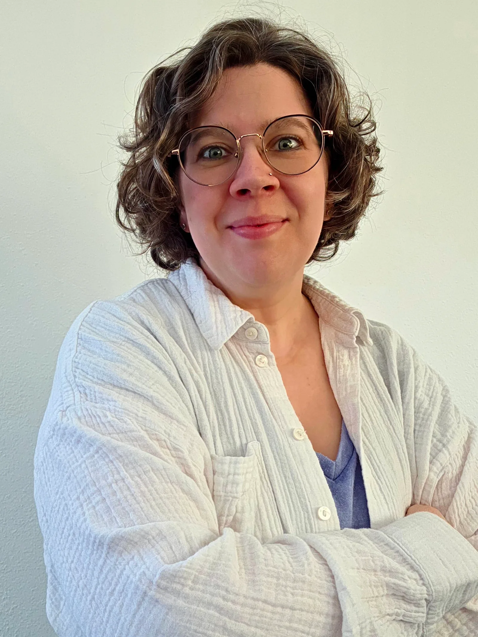 Porträt von Eva Waldburger mit Brille und beigefarbener Bluse, lächelnd