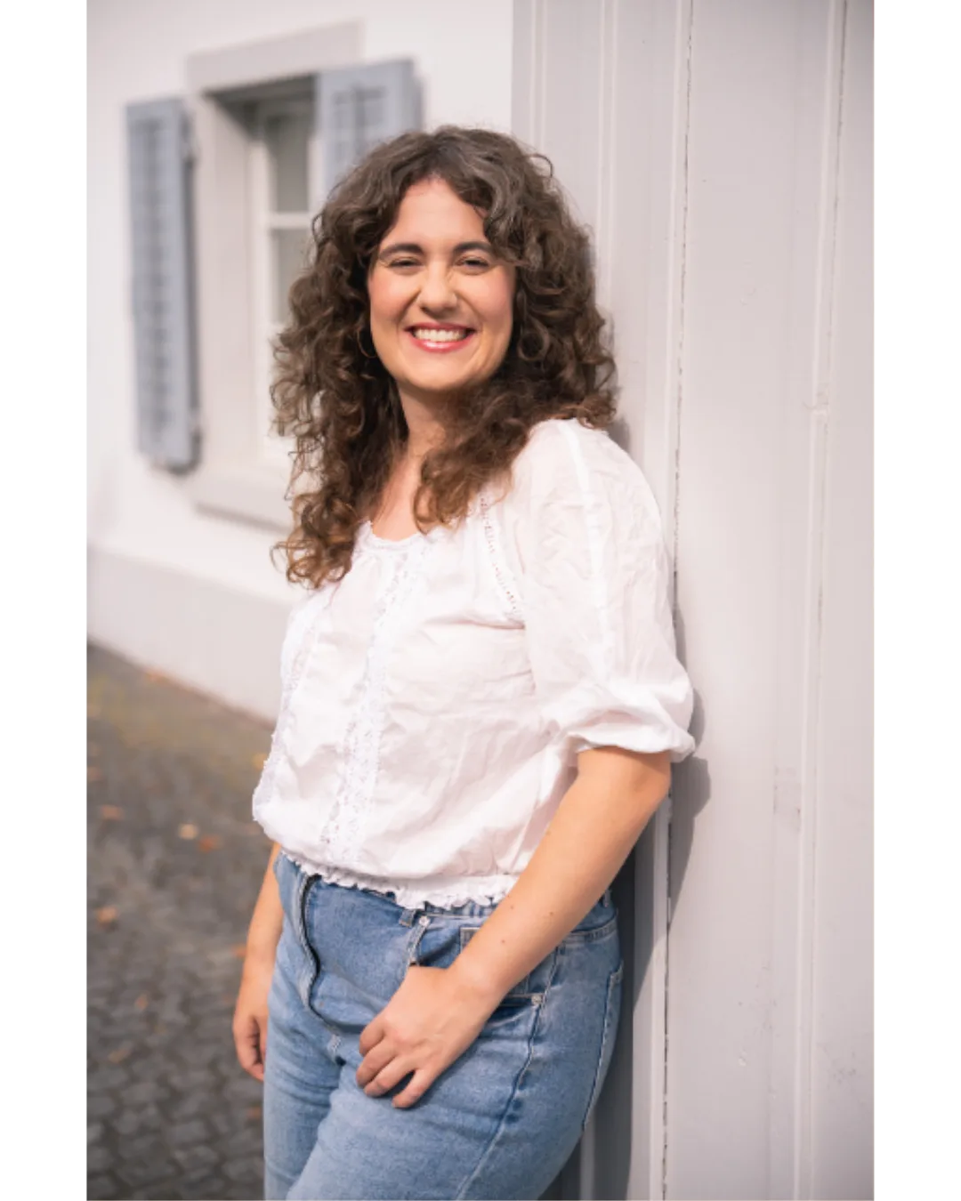 Porträt von Eliane Scherrer mit braunem lockigen Haar, lächelnd in Nahaufnahme