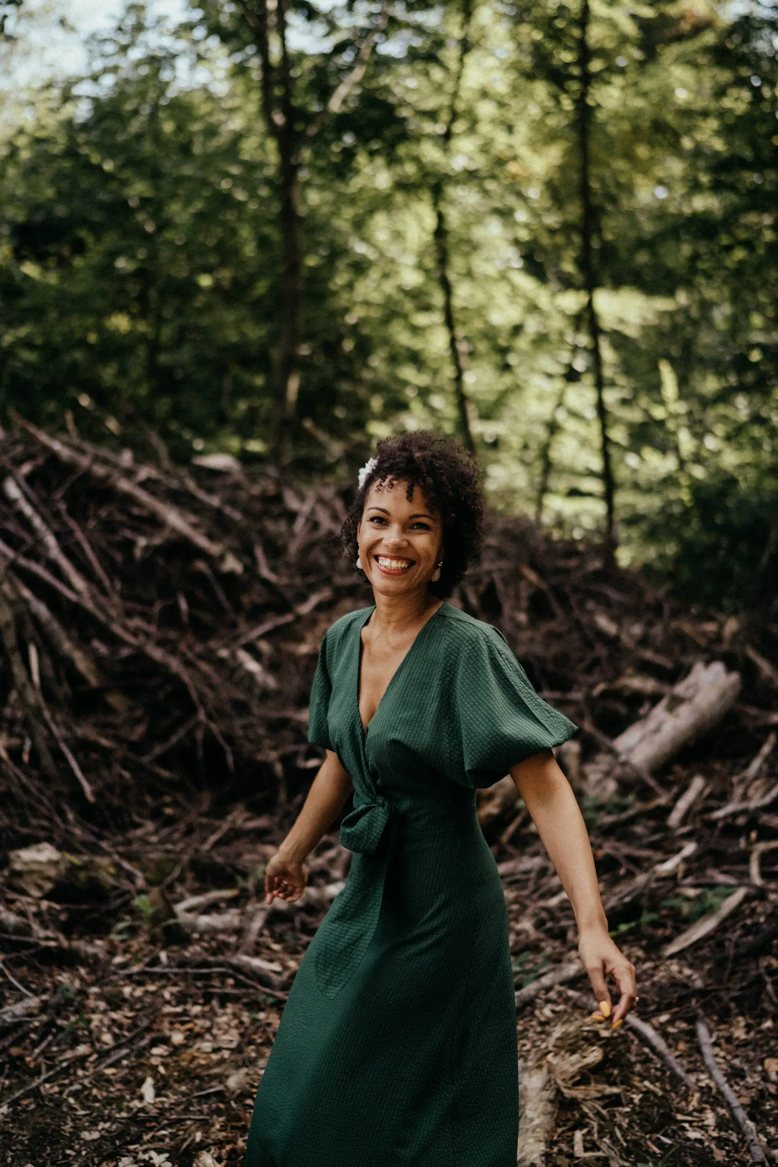 Porträtfoto von Rocio Stamm in grünem Kleid im Wald lächelnd
