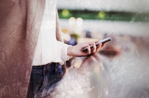 Hand mit Smartphone zur Buchung oder Navigation einer Stadtrallye