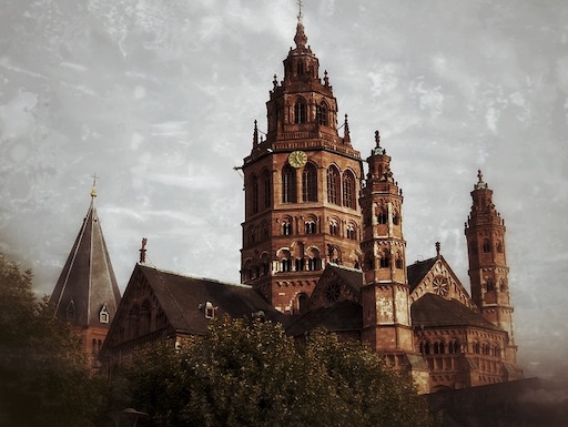 Selbstgeführte Stadtrallye Mainz 5 Historische Kirche mit roten Backsteinturm und verschachtelten Dächern in Mainz