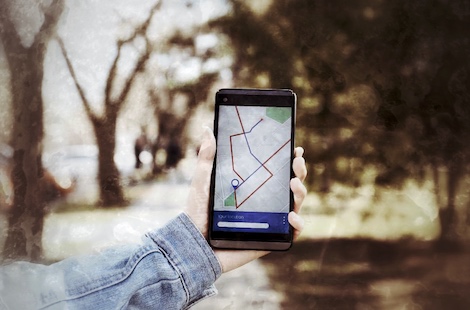 Selbstgeführte Stadtrallye Mainz 7 Hand hält Smartphone mit Karten-Navigation in grüner Landschaft, GPS-Navigation für Rätsel