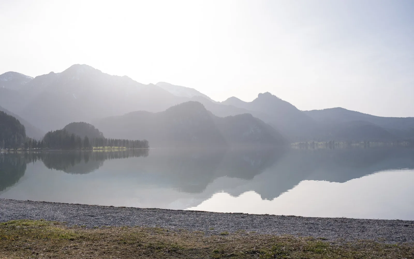 Stille Seelandschaft mit Bergen und Spiegelung, minimalistisch und beruhigend