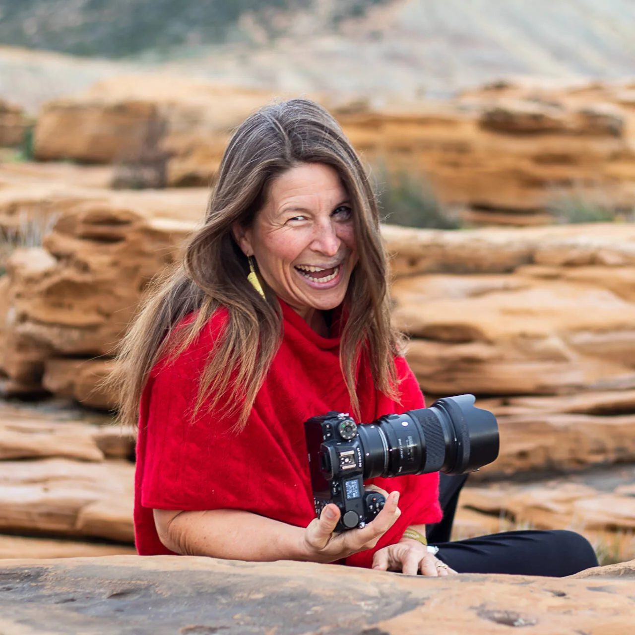 Porträt der Fotografin Michaela Grönnebaum mit rotem Shirt und professioneller Kamera