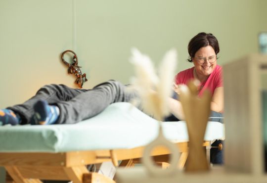 Marlen Kästner massiert Patient auf Behandlungsliege, professionelles Setting
