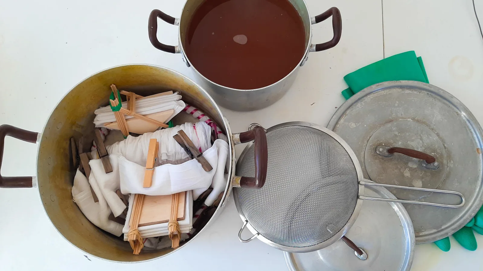 Shibori-Muster Onlinekurs für Beginner – Videokurs zum Stofffärben 5 Arbeitsfläche mit Metalltöpfen, gebundenen Stoffen und natürlichen Farbstoffen