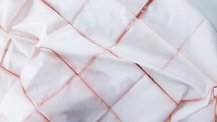 Shibori-Muster Onlinekurs für Beginner – Videokurs zum Stofffärben 2 Nahaufnahme eines blassrosa gefärbten Shibori-Tuchs mit geometrischen Mustern