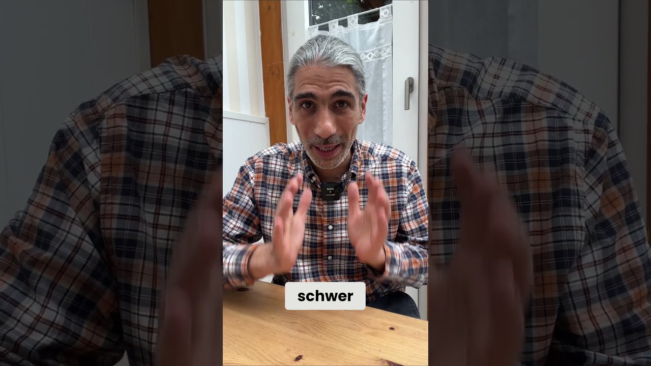 Daniel Dirks in kariertem Hemd gestikulierend am Tisch