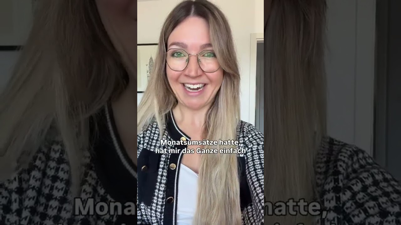 Julia Trost mit Brille und Jacke, lächelnd vor Türrahmen