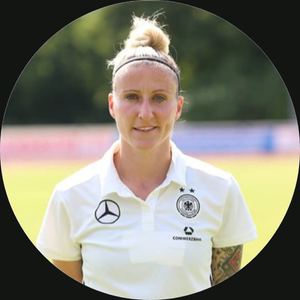 Anja Mittag in weißem DFB-Trainertrikot mit Deutschlandflagge, Porträt-Headshot