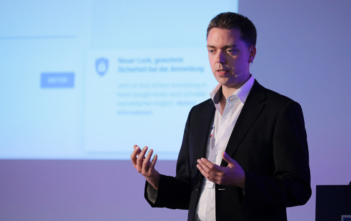 Christoph Mohr präsentiert vor blauem Hintergrund mit Folieninhalt