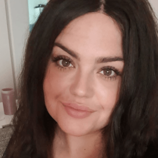 Porträt von Jess, dunkelhaarige Frau, subtiles Lächeln