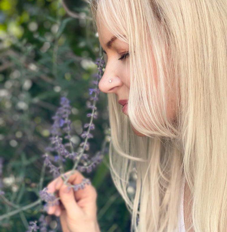 Porträt einer Frau mit blondem Haar neben Lavendelblüten, Seitenansicht