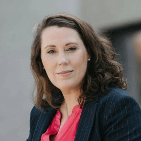 Portrait: Frau in dunklem Blazer mit rosa Bluse, professionelle Ausstrahlung