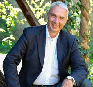 Älterer Mann mit weißem Haar und blauem Blazer, freundliches Porträt