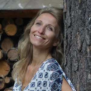 Portrait Jana Iger – blonde Frau mit Holzwand im Hintergrund