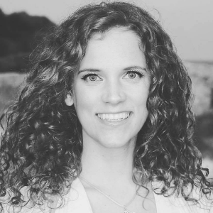 Schwarzweiß-Porträtfoto von Angelika Fürstler mit gelocktem Haar, lächelnd