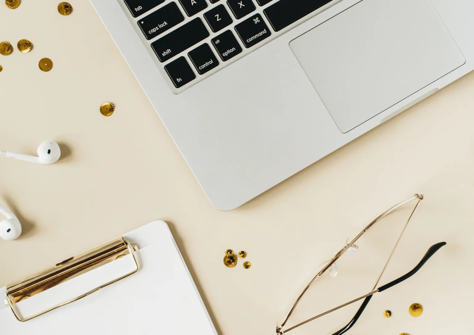 Story klar – Erzählcoaching für Experten von Insa Künkel 4 Laptop, Kopfhörer, Brille und Klemmbrett auf beigem Schreibtisch mit goldenen Elementen