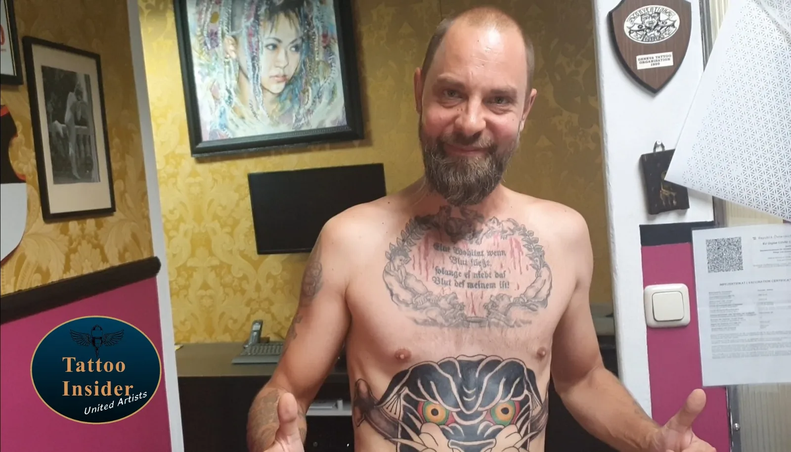 Mann mit großen Brust-Tattoos im gelb-roten Tattoo Studio
