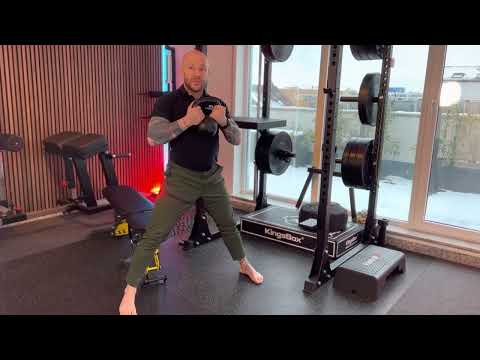 Mann führt Kurzhantel-Übung in Fitnessstudio vor