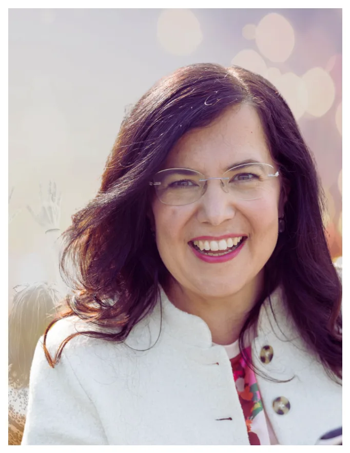 Porträt von Maria Husch, Kursleiterin, mit Brille und weißem Blazer lächelnd
